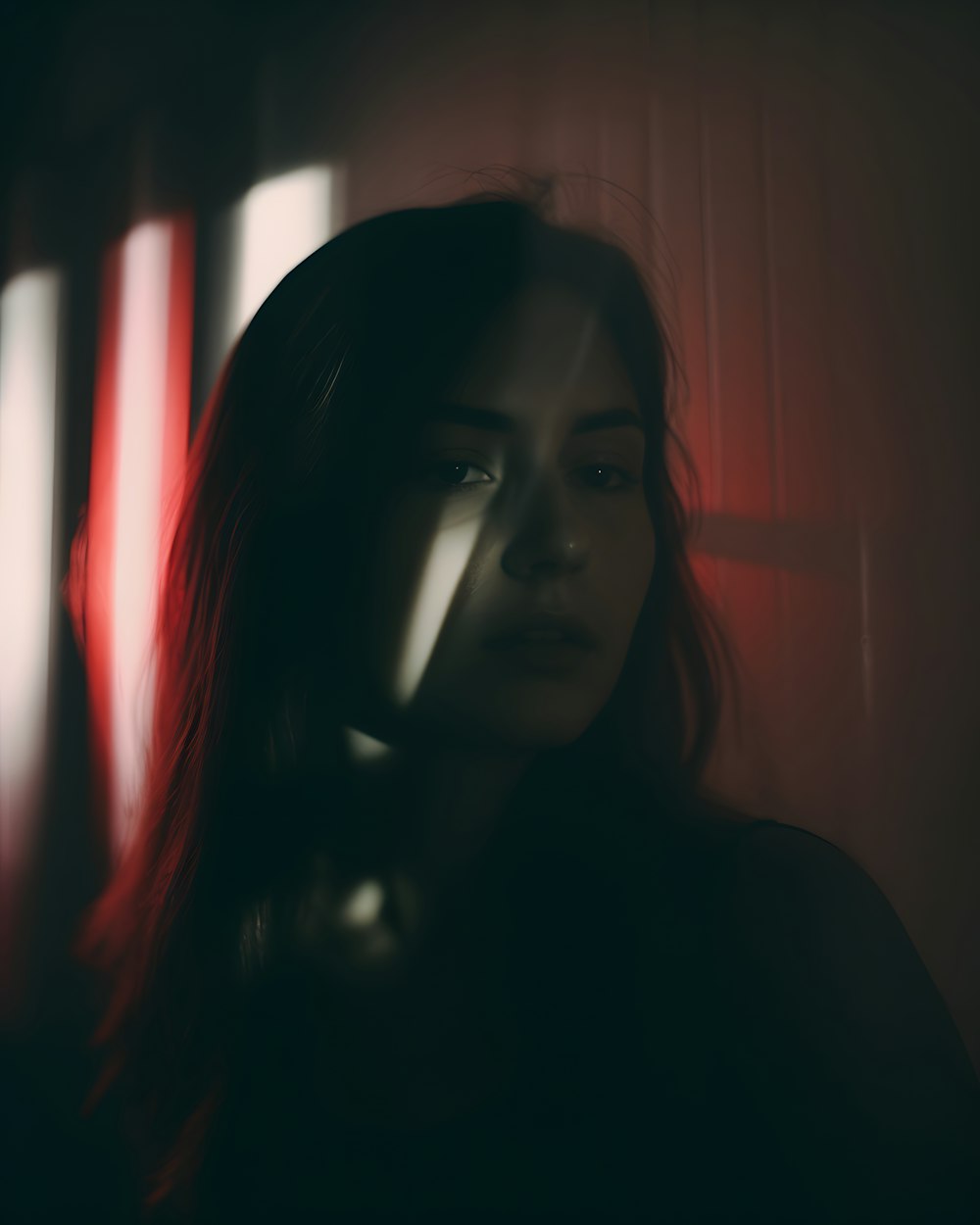 a woman with red hair standing in a dark room