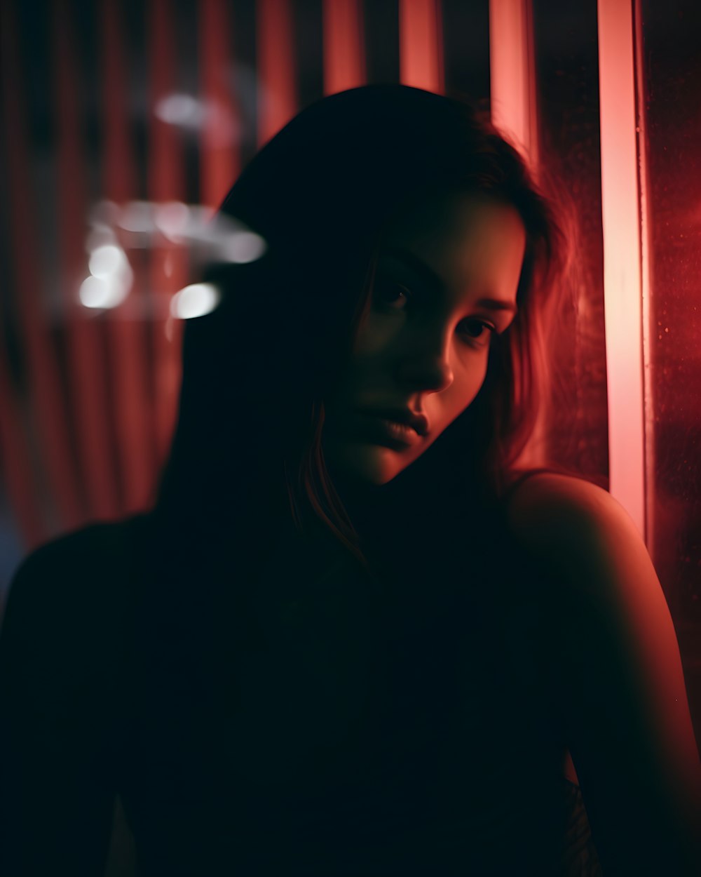 a woman standing in front of a red light