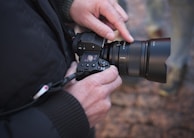 Close-up of a photographer adjusting camera settings during an outdoor shoot.
