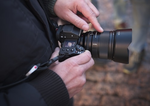 A photographer adjusting camera settings during an outdoor shoot.