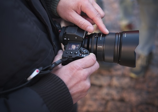 A candid shot of a photographer adjusting camera settings during an outdoor photo session.