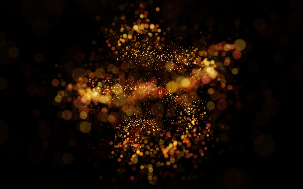 a blurry image of gold glitter on a black background