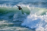 High-performance surfer riding a giant wave with spray flying.