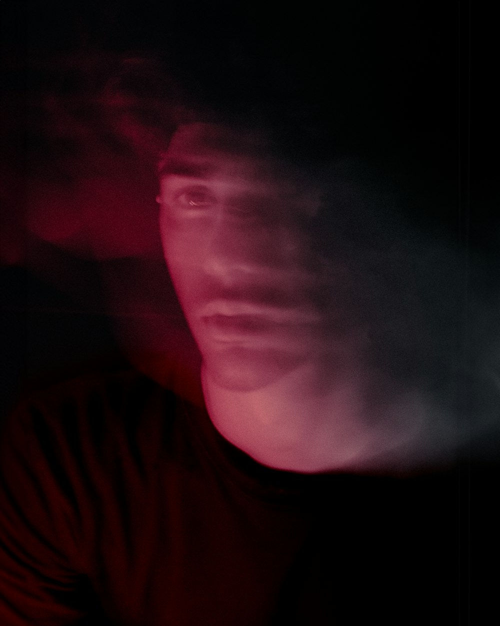 a man in a dark room with a red light