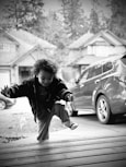a young boy jumping in the air on a wooden deck