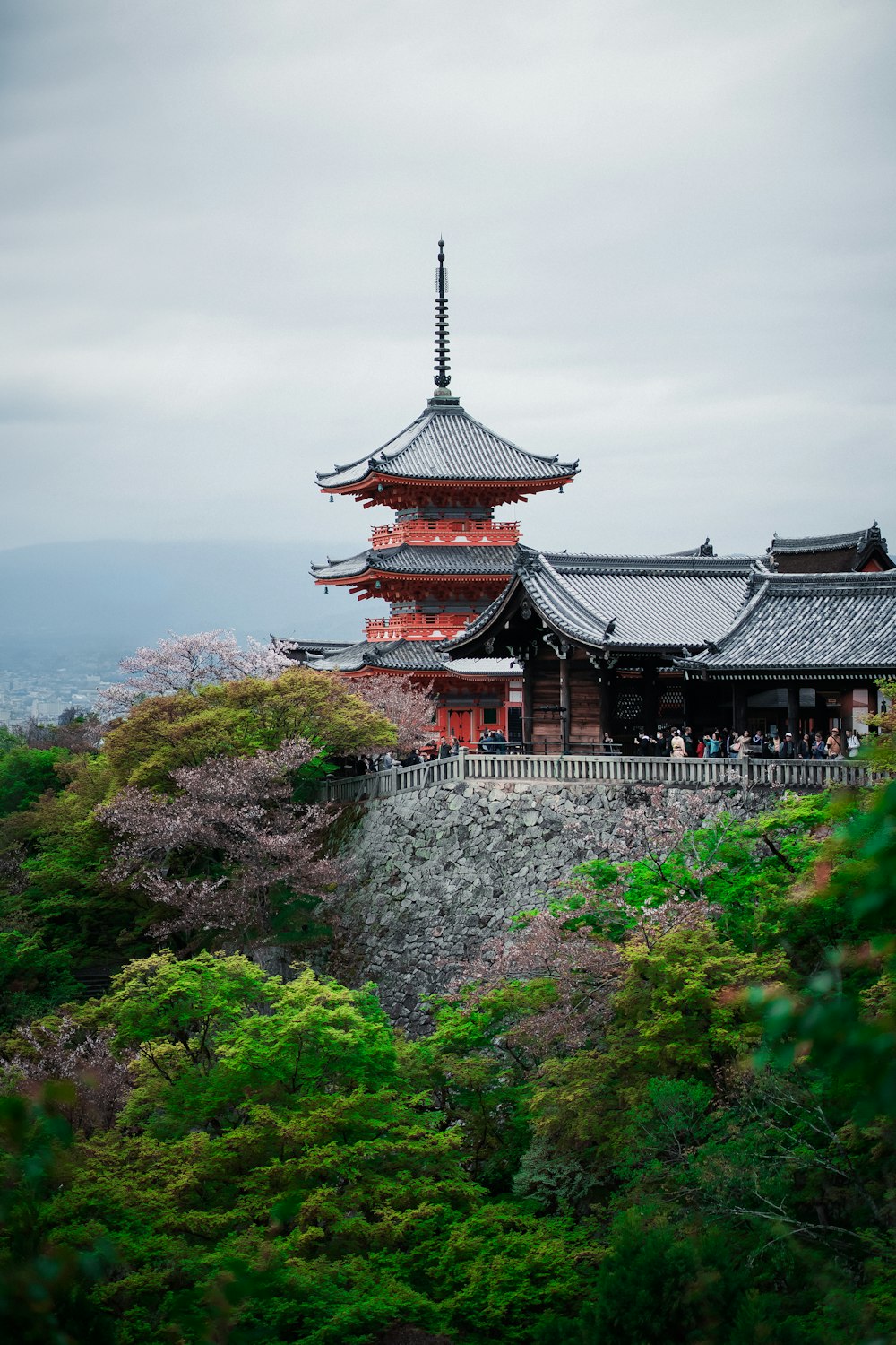 a tall building sitting on top of a lush green hillside