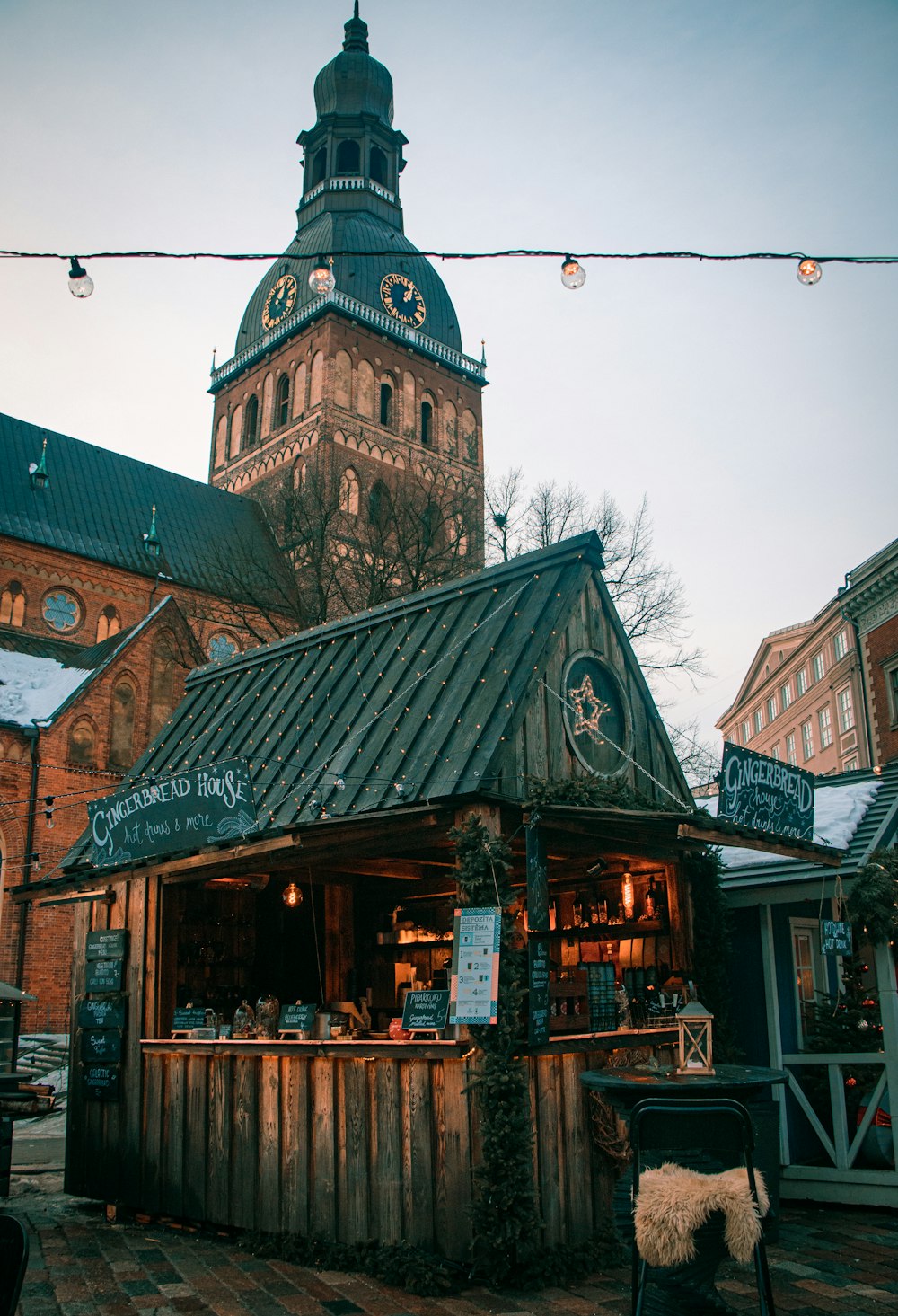 a small building with a clock tower in the background