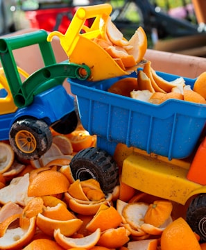 a toy truck filled with orange peels in a bin