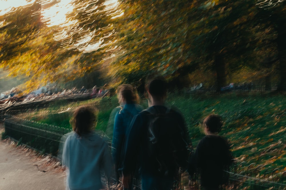 a group of people standing next to a lush green park