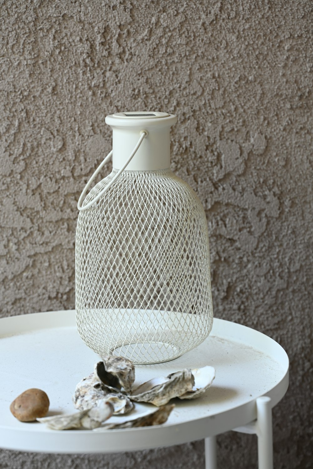 a white vase sitting on top of a white table