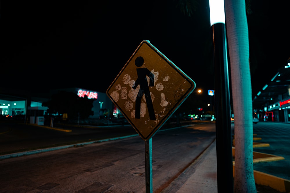 um sinal de travessia de pedestres na lateral da estrada