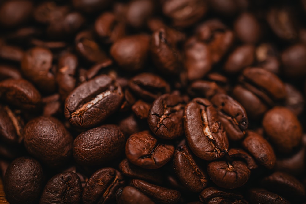 a pile of coffee beans sitting on top of a wooden table