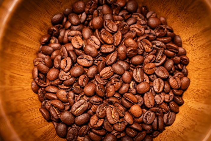 Close-up of freshly ground coffee powder in a rustic wooden bowl
