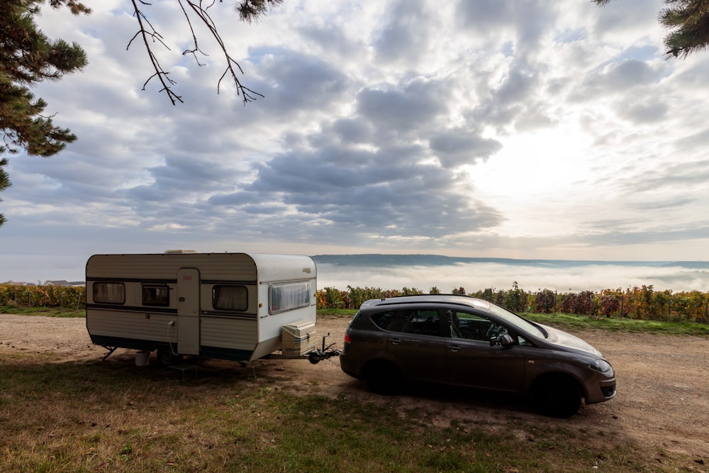 une voiture garée à côté d’un camping-car sur un chemin de terre
