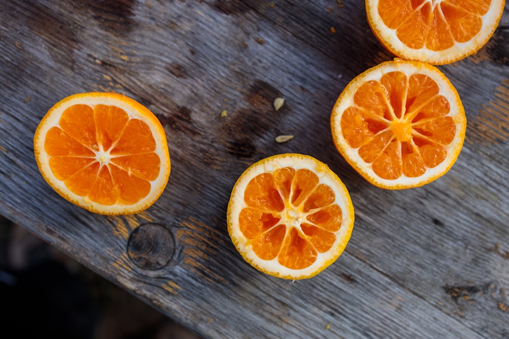 a group of oranges sitting on top of a wooden table