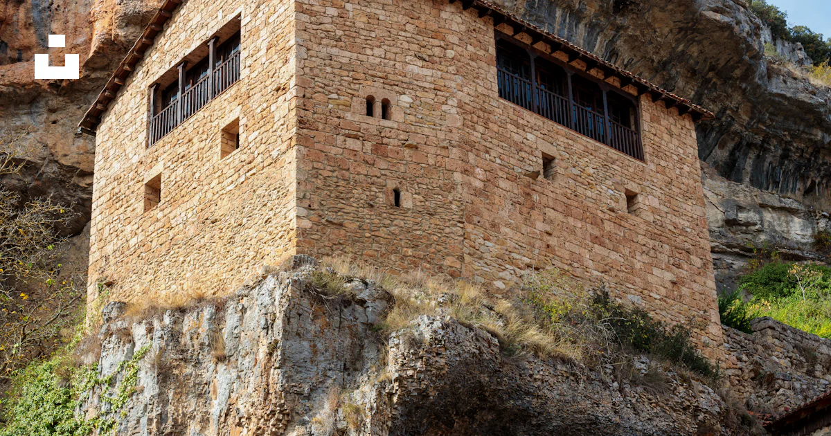 A stone building built into the side of a mountain photo – Free ...