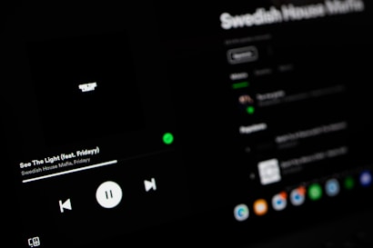 A dark-themed Spotify interface displaying the song 'See The Light' by Swedish House Mafia featuring Fridayy. The play controls are visible with options to play, pause, and skip tracks. The track list and album details are slightly blurred in the background.