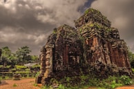 Moss-covered stone carvings of Bayon temple surrounded by lush jungle.