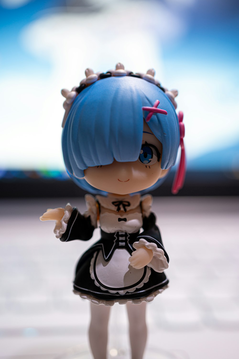 a doll with blue hair wearing a black and white outfit