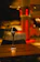 Close-up shot of a handmade wooden lamp casting warm light on a rustic table.