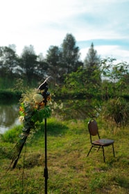A solemn ceremony setup with flowers and a microphone in a peaceful outdoor setting.