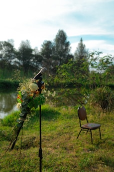 A solemn ceremony setup with flowers and a microphone in a peaceful outdoor setting.