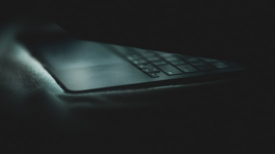 Close-up of a well-used keyboard with worn keys glowing softly under warm light.
