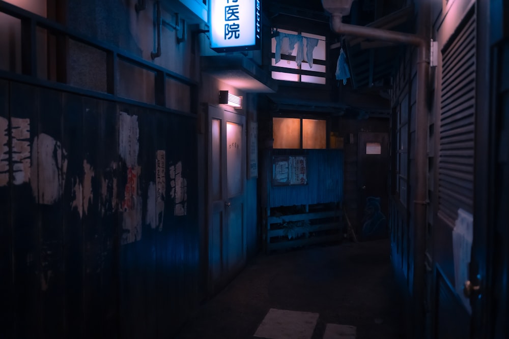 a dark alley way with a neon sign hanging from the ceiling
