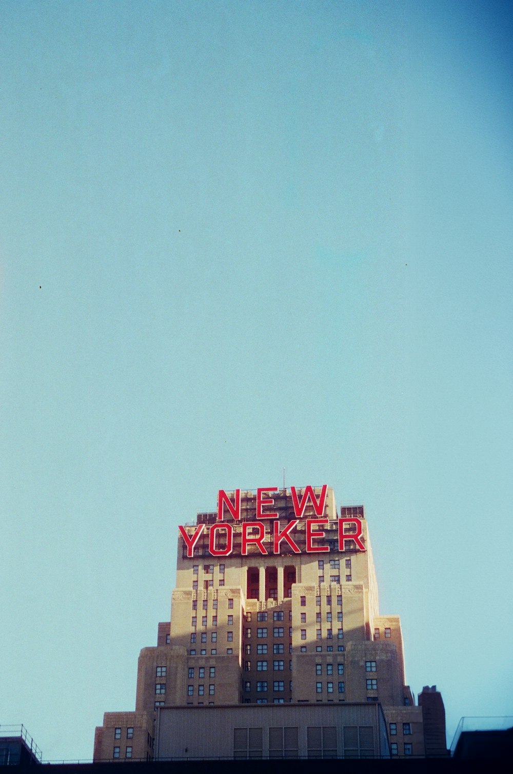 a very tall building with a neon new york sign on top