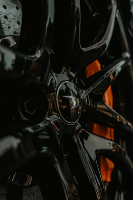 Close-up of a meticulously detailed wheel rim with glossy black finish and sharp lighting.