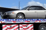 a flatbed tow truck with a silver car on it