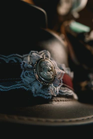 Close-up of a delicate vintage brooch resting on a soft lace fabric.