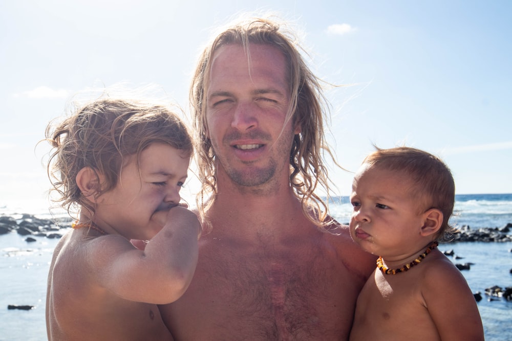 a man with three children on a beach
