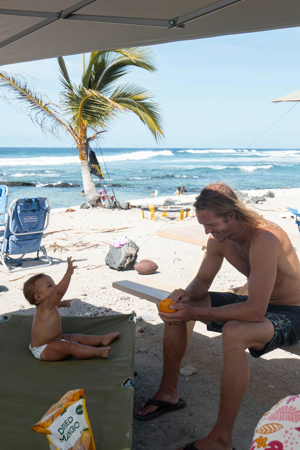 a man sitting on a bench next to a little boy