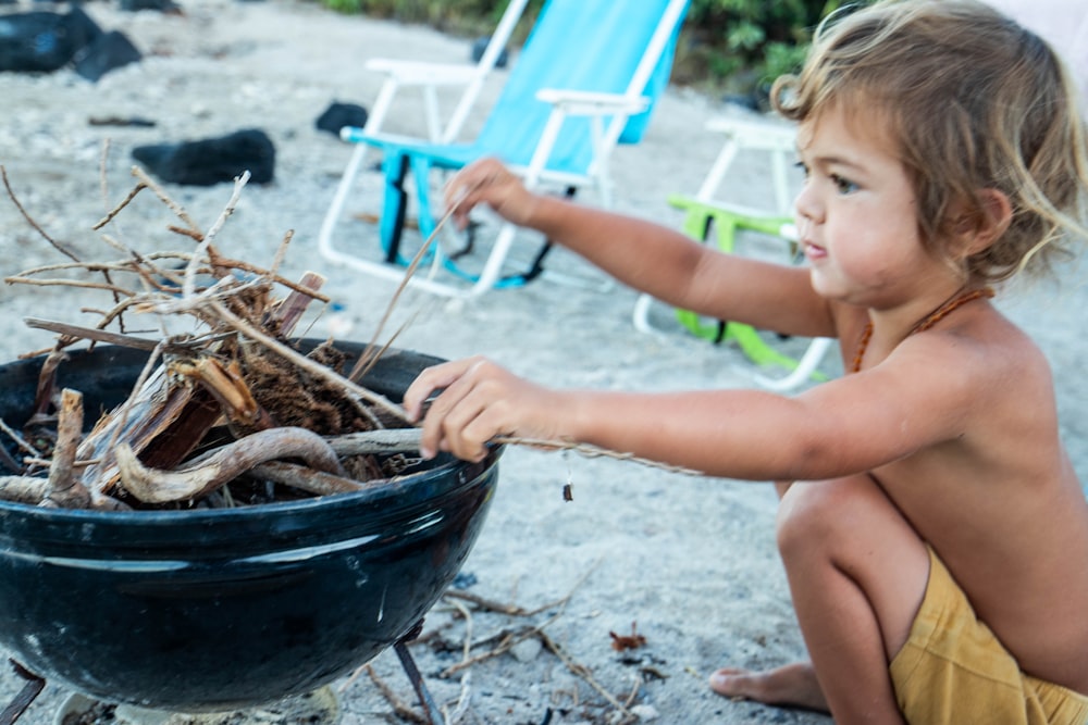 une petite fille qui est assise dans un bol