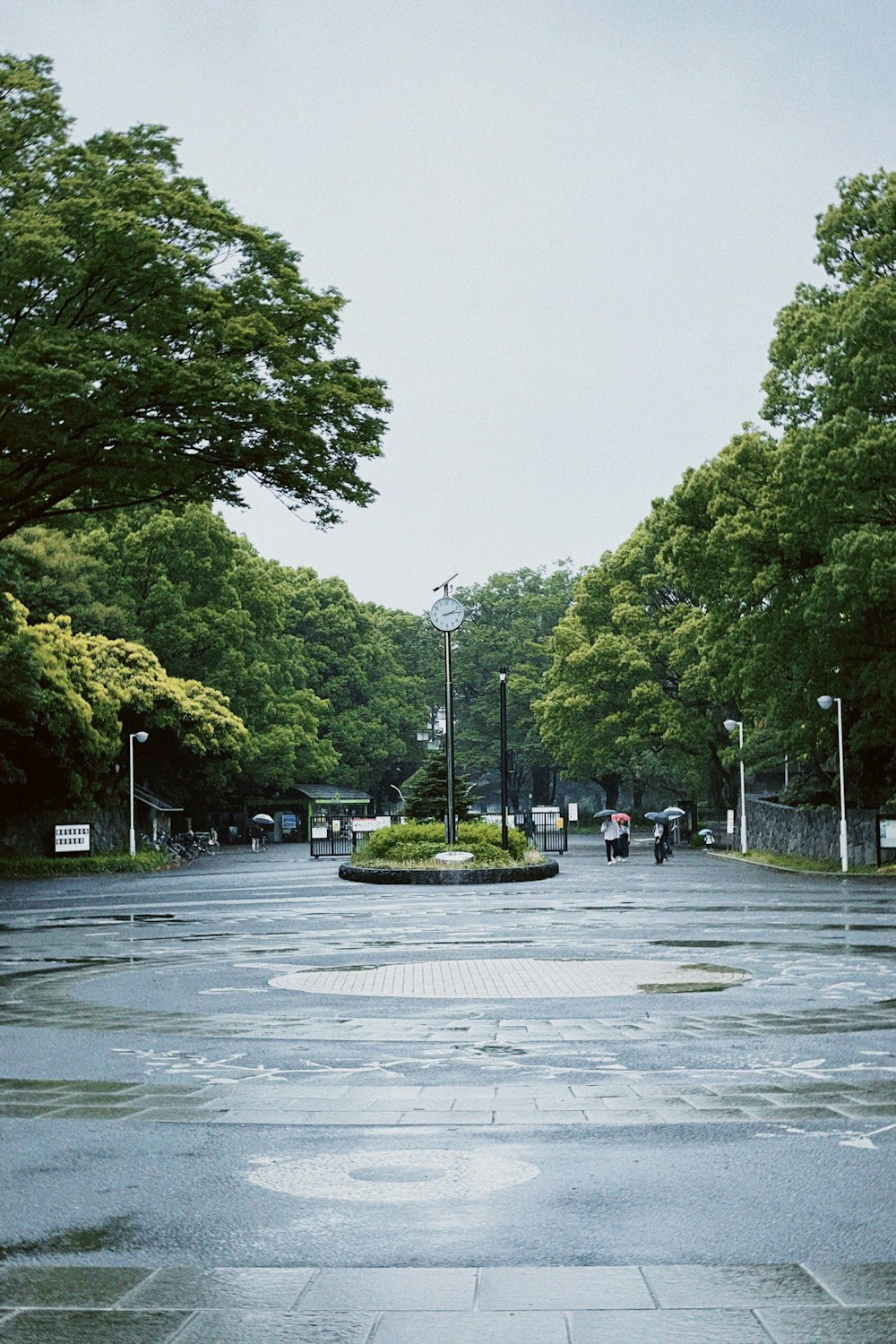 a wet street with a clock tower in the distance