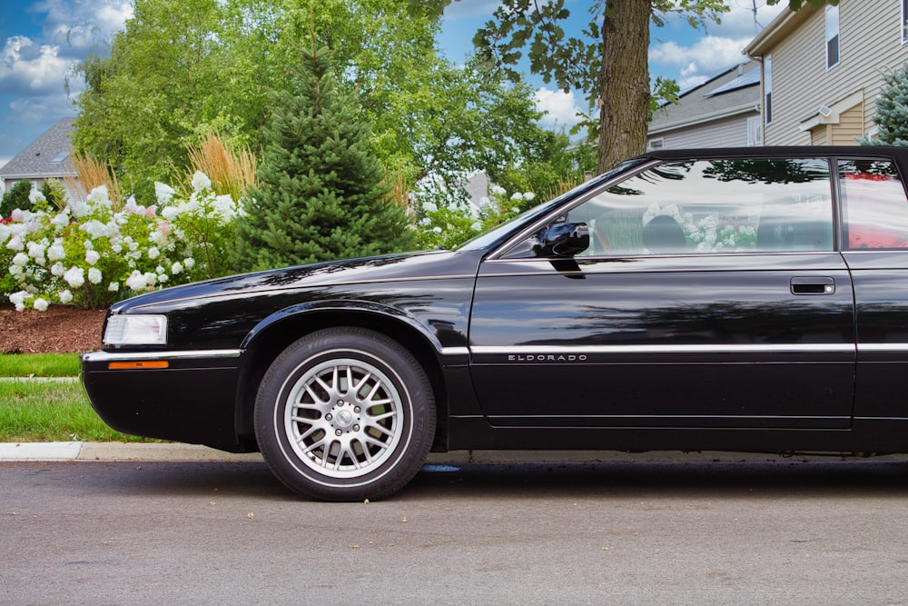 a black sports car parked in front of a house