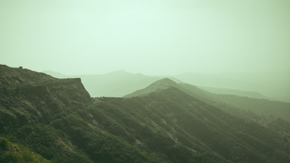 a view of a mountain range in a foggy day