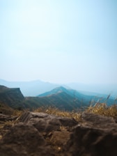 A panoramic view of a serene Texas landscape with rolling hills and a few newly developed residential lots under a clear blue sky.