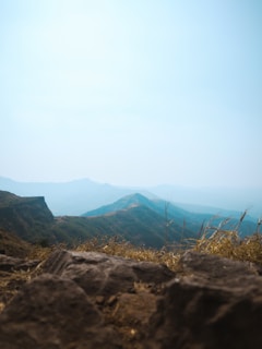 A panoramic view of rolling hills under a bright blue sky.