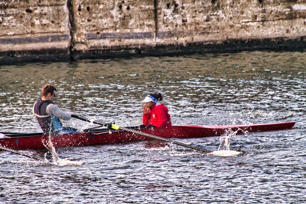 a man and a woman in a red canoe