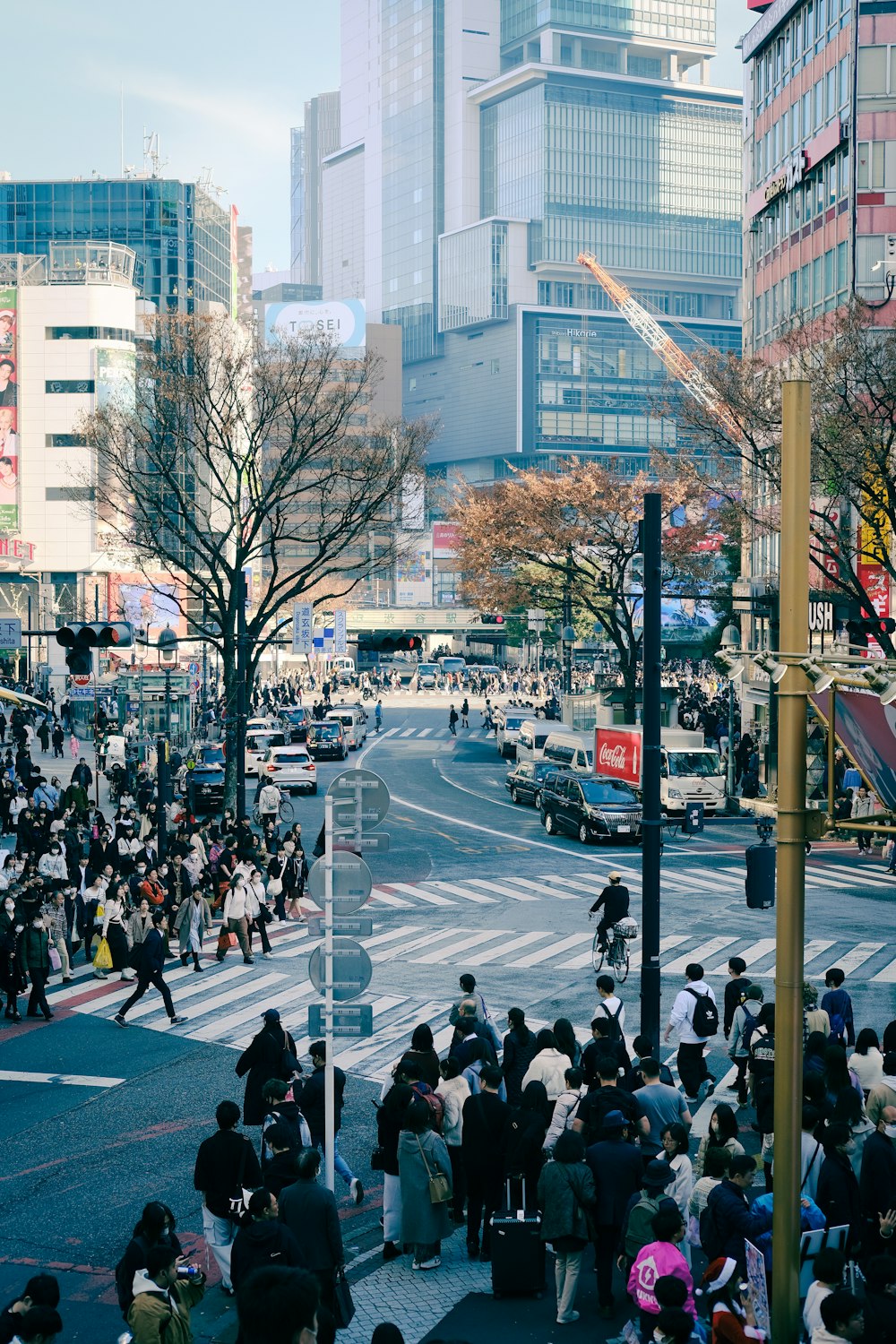 a crowd of people walking down a street next to tall buildings