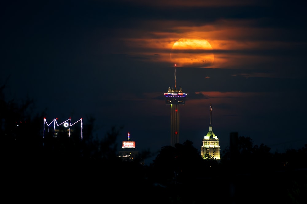 a full moon is seen over a city at night