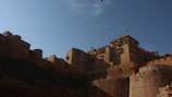 A panoramic view of a historic fort silhouetted against a clear blue sky.