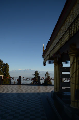 A serene temple courtyard bathed in golden sunlight with saffron and blue decorations.