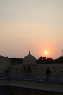 A peaceful view of the madrasa building at sunset with warm light glowing.