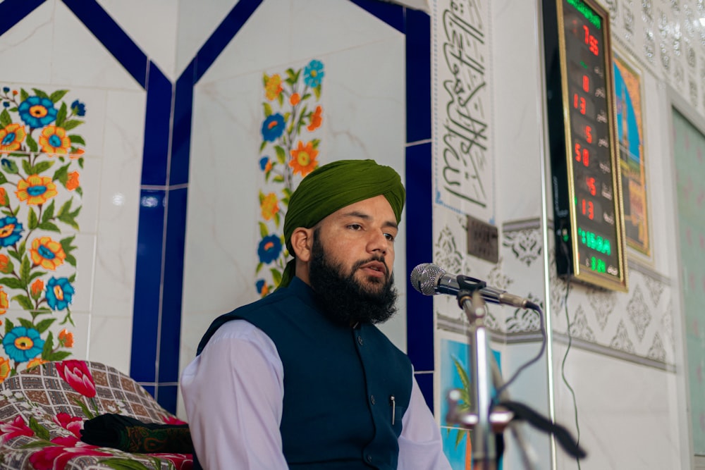 a man with a green turban speaking into a microphone