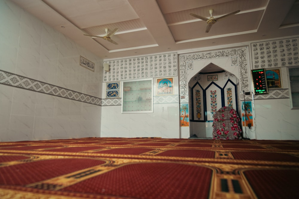 a room with a carpet, ceiling fan and pictures on the wall