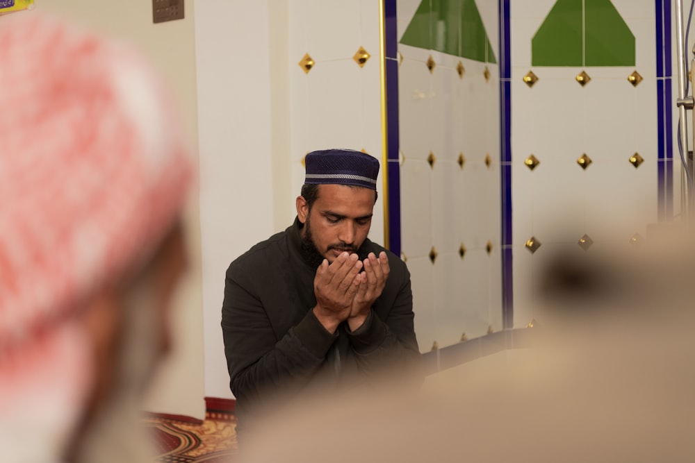 a man sitting in a room with his hands together