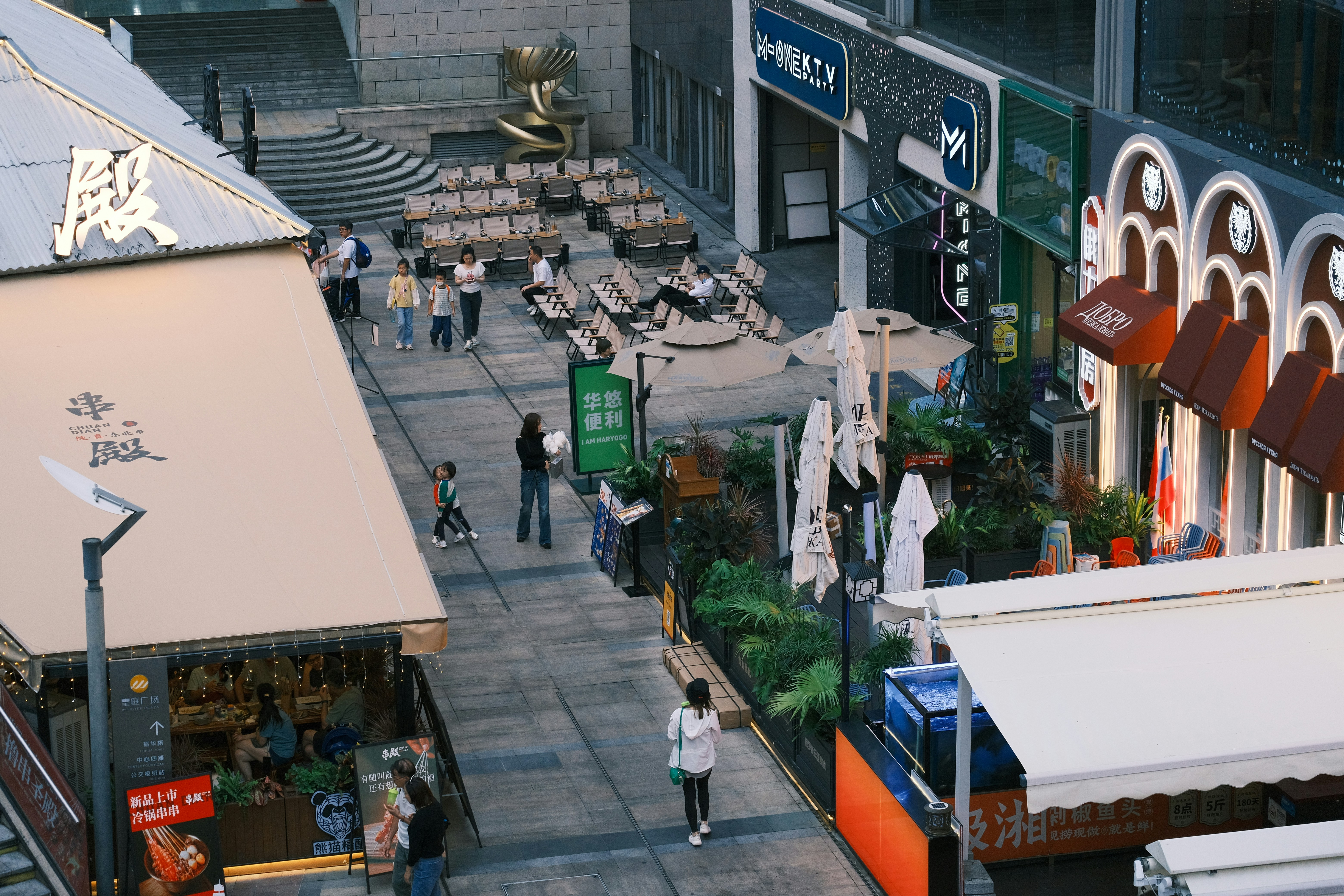 a group of people walking down a street next to a building